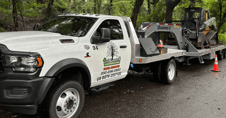 Crane lifting a large fallen tree off a residential roof after a hurricane in North Carolina